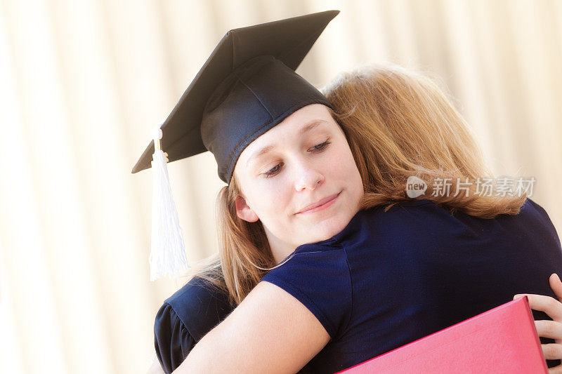 父母在大学毕业典礼上祝贺拥抱情绪激动的女儿