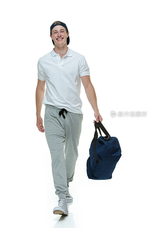 微笑的男人拿着行李袋走路