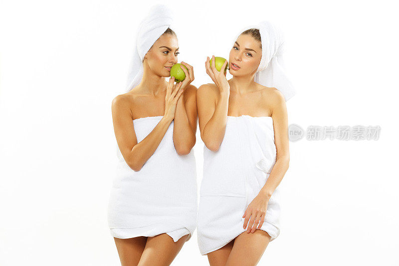 两个快乐的少女淋浴后玩苹果