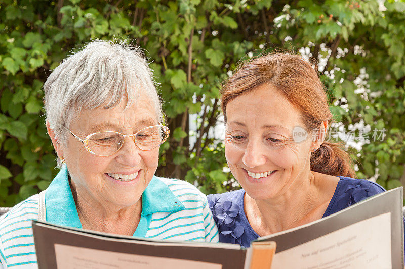 年长的女性和看护者在看菜单