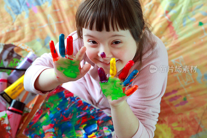 一个双手涂着颜料的小女孩