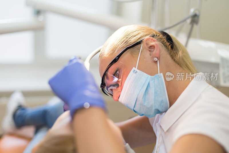 女牙医正在处理她的病人侧面照片