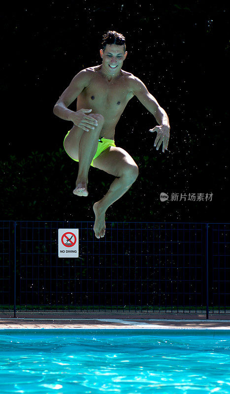 年轻人在游泳池跳水。请勿在背景上潜水