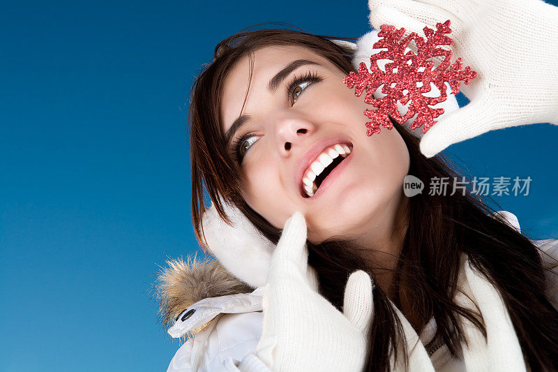 微笑的女性捧着红色雪花点缀