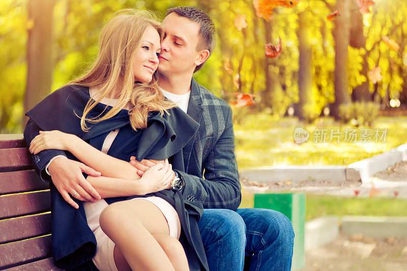 幸福的年轻夫妇在秋天的公园