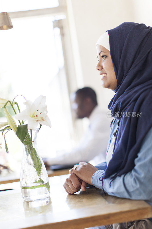 一名穆斯林妇女坐在开普敦的桌子旁