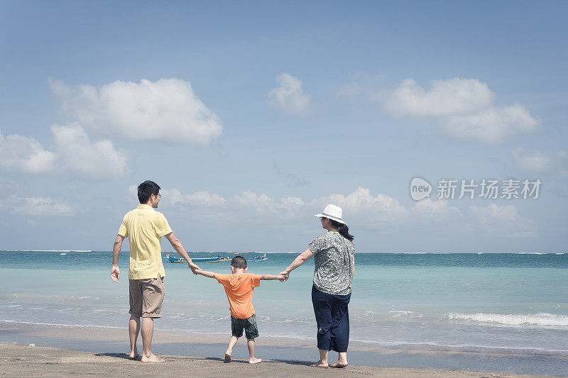 一家人带着一个孩子在海滩上玩