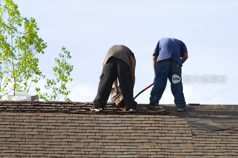 屋顶工人在屋顶上铺瓦片