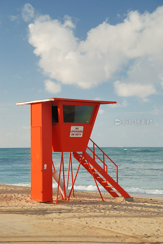橙色救生员站在阳光明媚的夏威夷海滩上