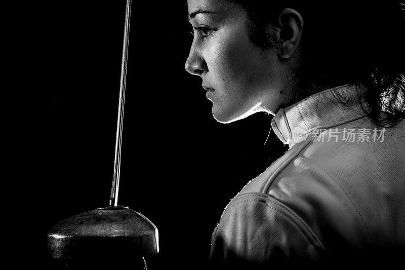 身着白色剑术服的女子用剑练习的肖像。身着白色剑术服的女子用剑练习的肖像。