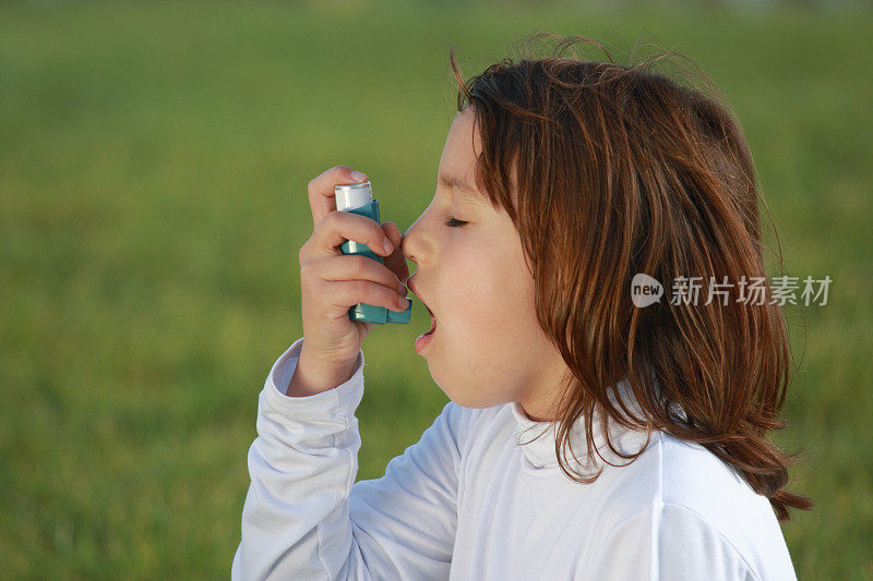 小女孩在外面用她的哮喘吸入器
