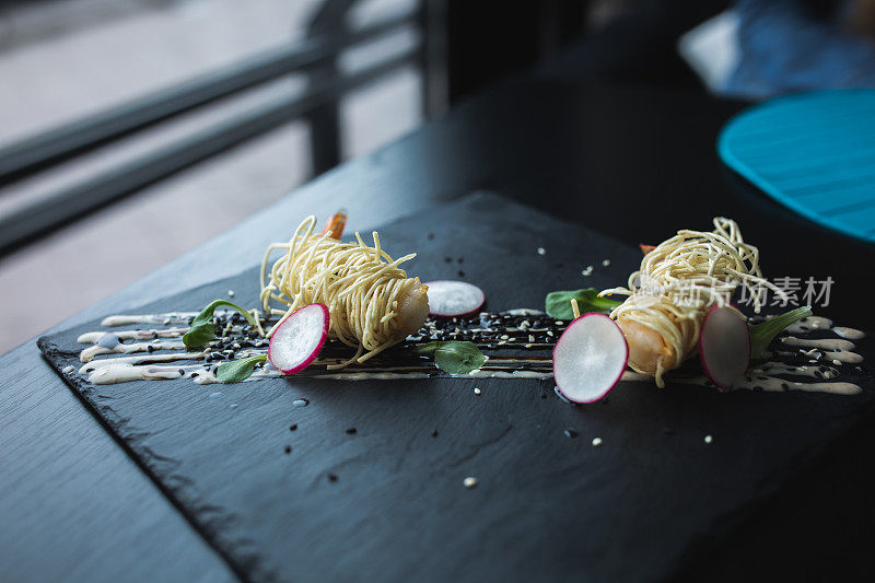 黑盘酱面虎虾。亚洲食物的背景。吃conceprt。餐厅的地方与木桌。