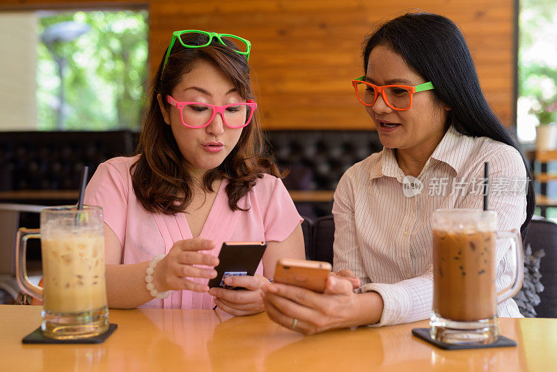 成熟的亚洲女性朋友在咖啡店闲逛的肖像