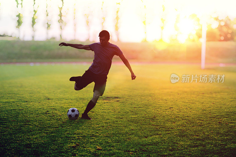 日落时分，足球运动员正在体育场投球。