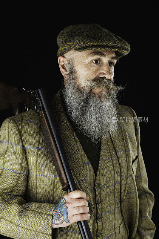 五十多岁的蓄着胡子的男人，拿着猎枪