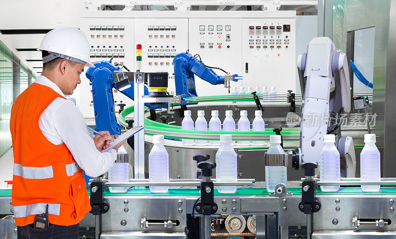 工程师在工厂的饮料生产车间检查自动化机器人