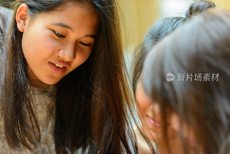 年轻的亚洲女性朋友一起在餐馆里闲逛的照片