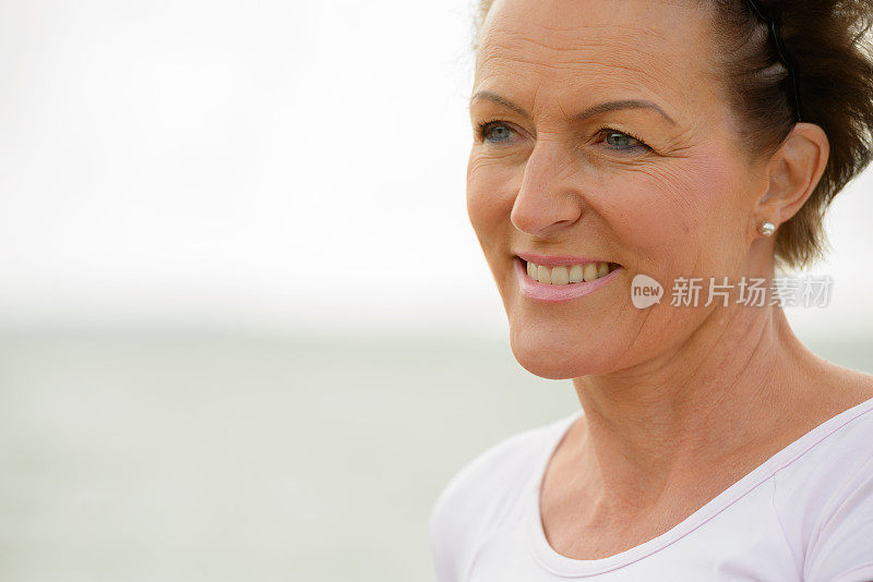 成熟美丽的女人对风景秀丽的湖在图尔库芬兰