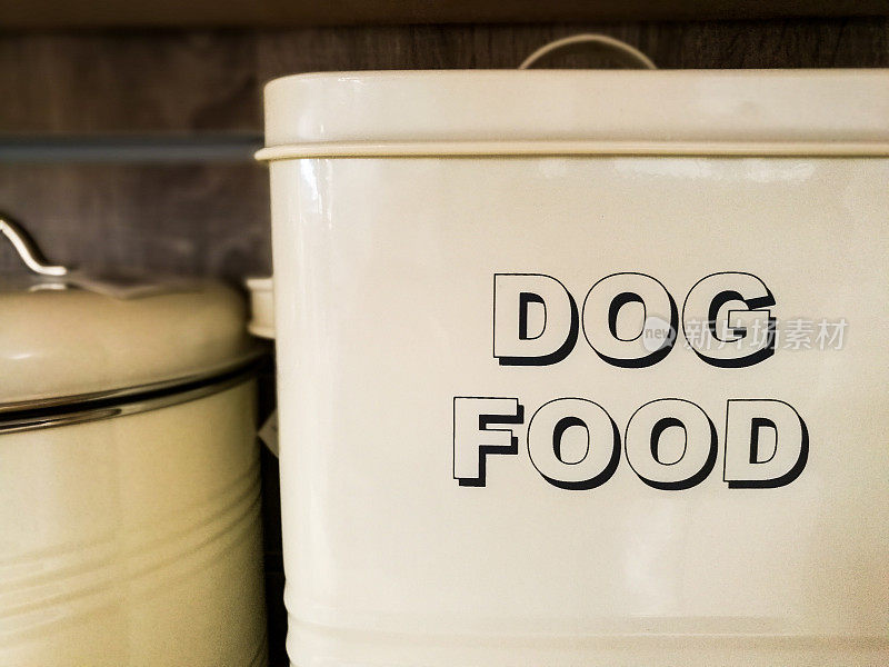 一个白色的金属罐，上面用粗体字写着“狗粮”