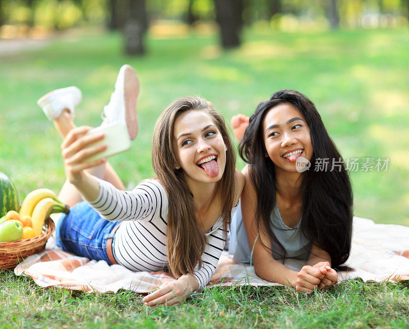 白人和亚洲年轻女子自拍和展示舌头