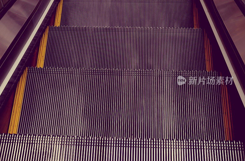 抽象的商场自动扶梯，向上的楼梯，黄色的带子。金属线钢