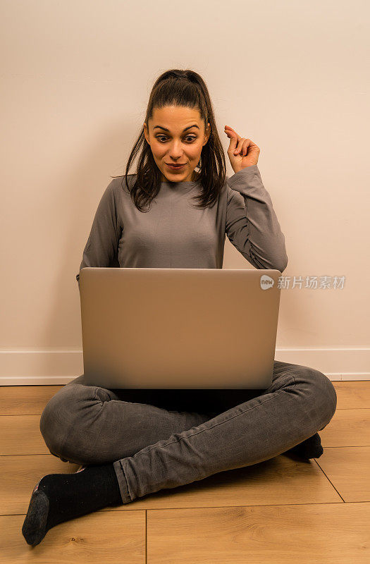 坐在地板上拿着笔记本电脑的女人也有同样的想法