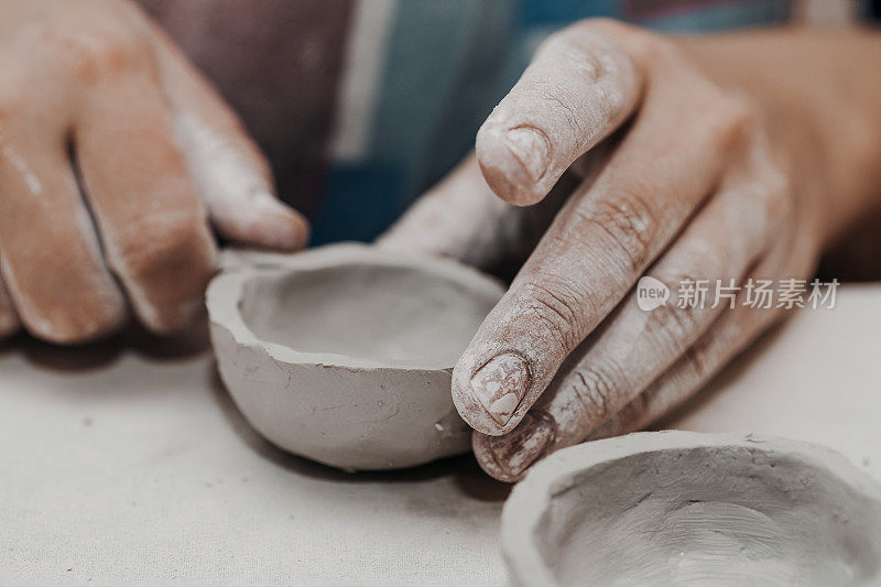 女陶工用陶土工作，工匠的手靠近