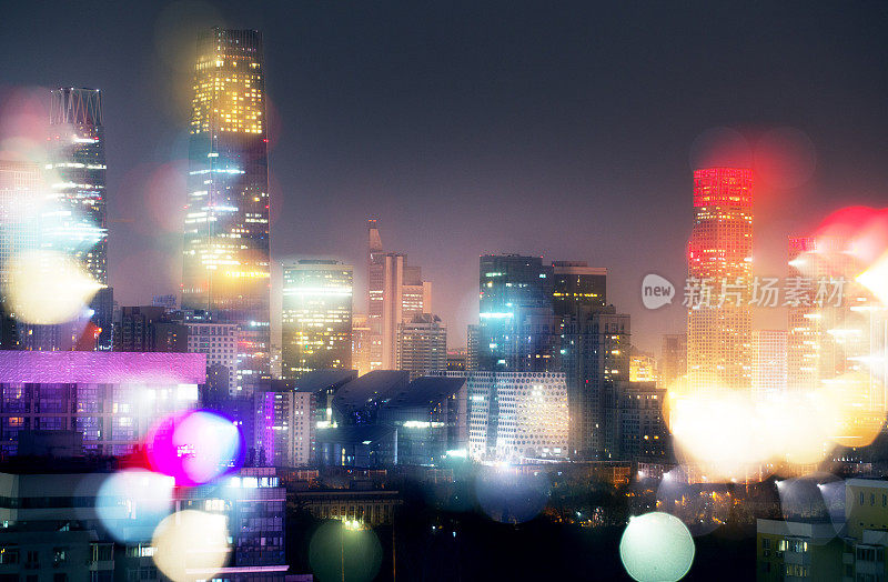 夜景迷离的散景灯光照亮了中国北京的城市办公楼