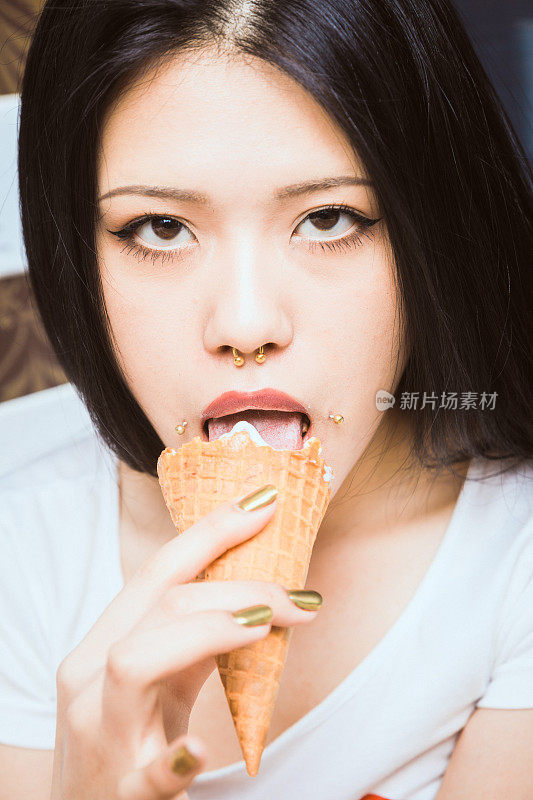 年轻的亚洲女人在吃冰淇淋