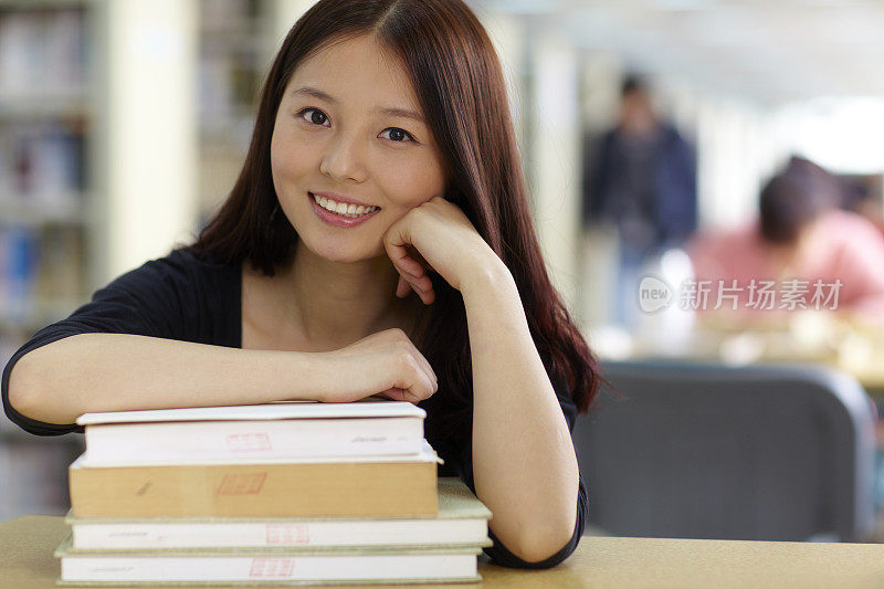 一个漂亮的亚洲女大学生在图书馆学习