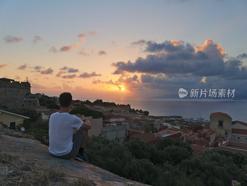 年轻人在海边小镇米拉佐和大海上看日出