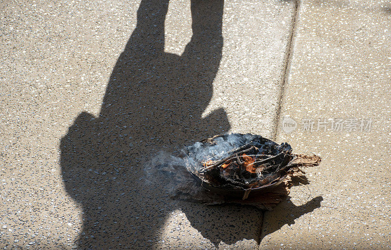 土著男子的影子和他的火焰和烟从树皮船和叶子用于传统的澳大利亚土著吸烟仪式。