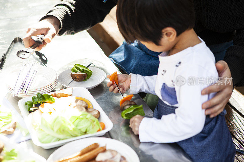 父亲和儿子在一起做烤肉