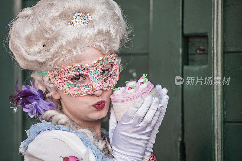 美丽的年轻女子在威尼斯狂欢节的花式甜蛋糕服装