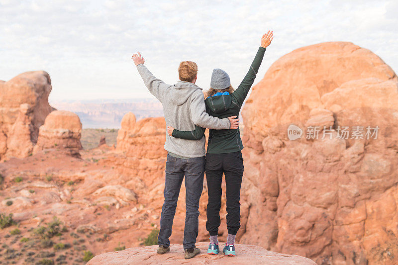 两个年轻的徒步旅行者在犹他州的沙漠中欣赏日出