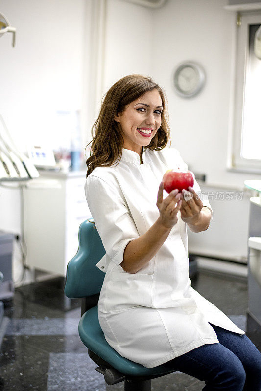 女牙医手里拿着一个红苹果