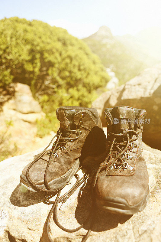 穿着旧的登山靴走在阳光明媚的山路上