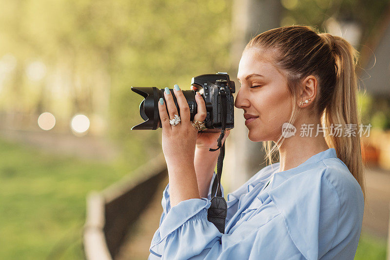 年轻女子用单反相机拍照