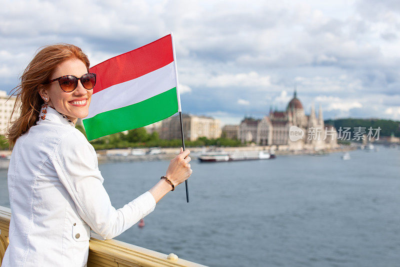 在布达佩斯，快乐的年轻女子举着匈牙利国旗