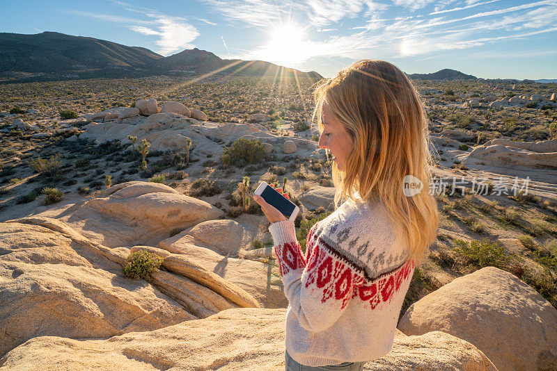 年轻女子在用智能手机发短信;在美国的加州，人们去探索大自然