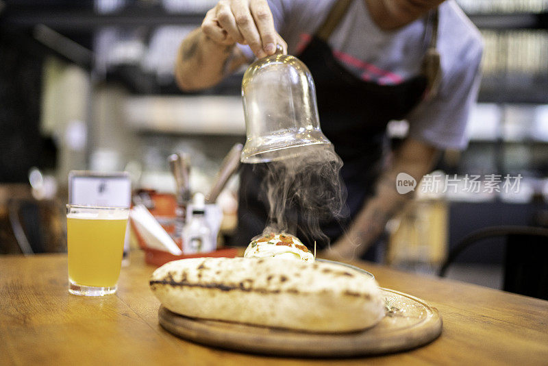 侍者端上皮塔饼和水牛芝士三明治