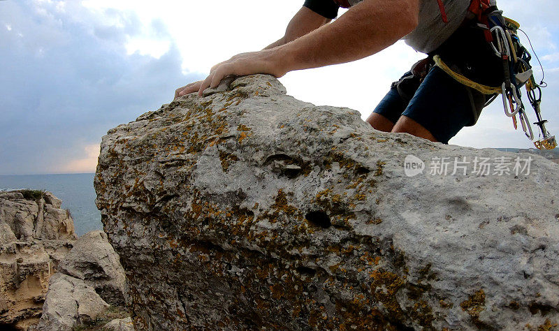 登山者在日出时登上岩石顶峰