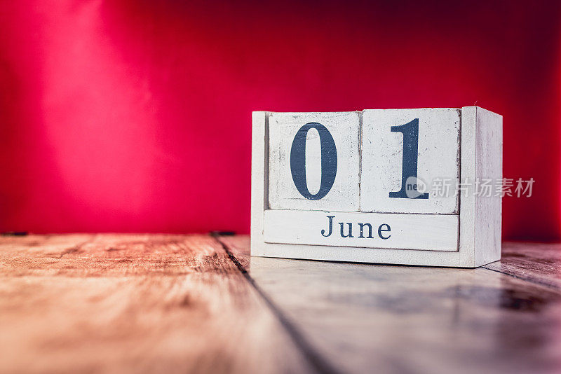 6月1日。月1日，日历放在商务办公室的桌子上，工作场所以鲜艳的栗色为背景。夏天的时间