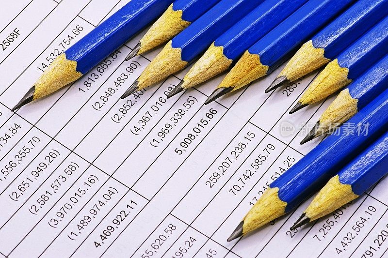 锋利的蓝色铅笔在财务报表上。