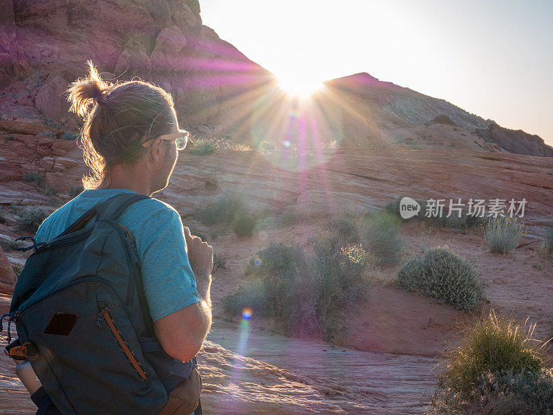 一个徒步旅行者在日出时凝视着红砂岩