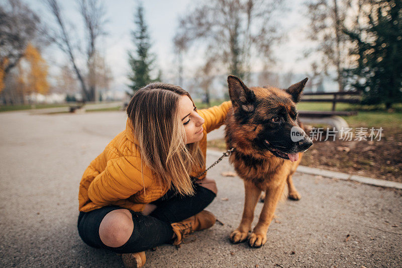 年轻女子和德国牧羊犬在公园里玩