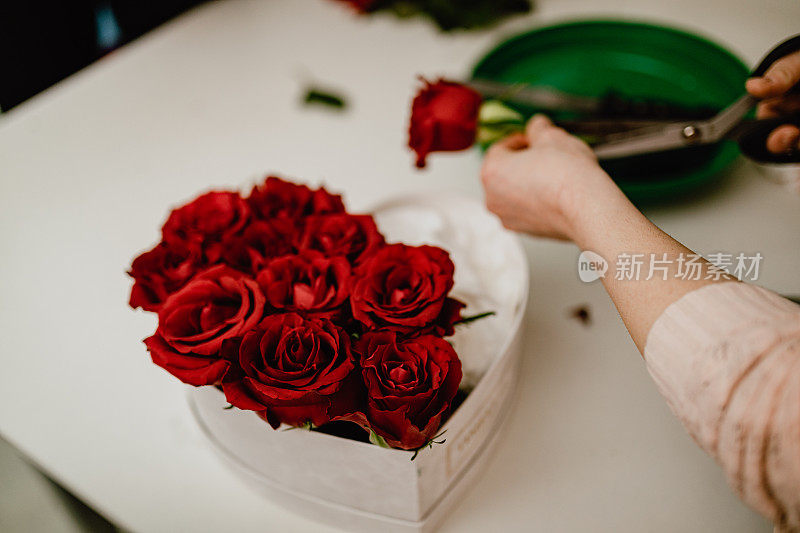 在花店做红玫瑰礼盒的女人