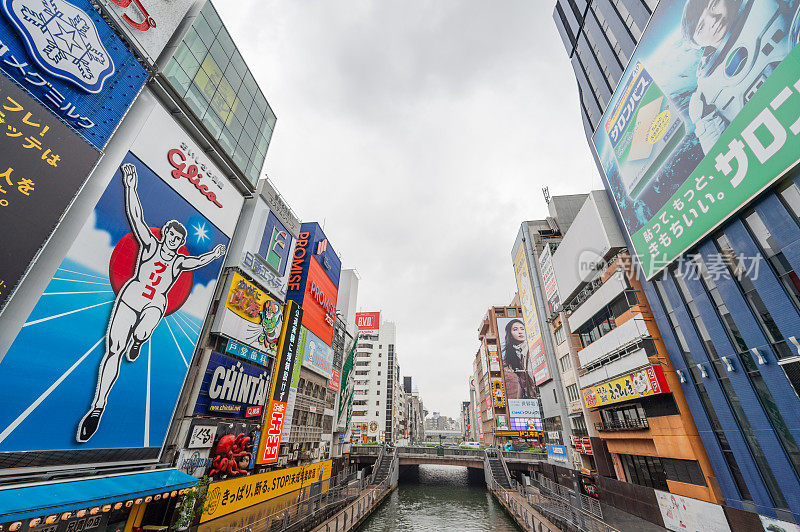 在日本大阪的道顿堀，五颜六色的广告牌照亮了大阪夜市周围的商店和零售店