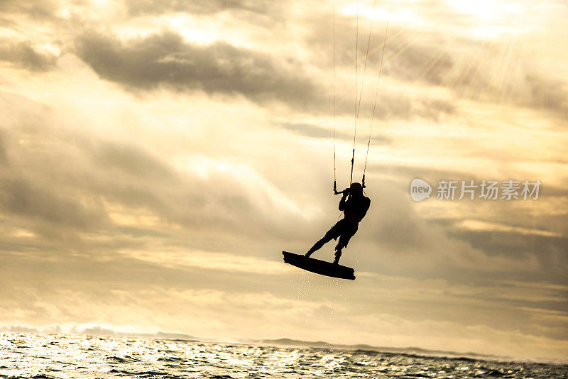 风筝滑板时一个人在空中飞行的剪影。