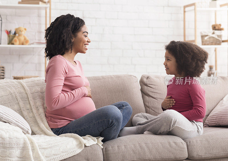 期待的妈妈告诉她的小女儿关于怀孕和摸肚子
